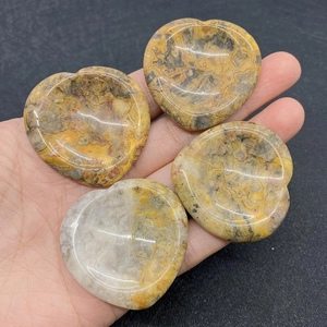 Pierres de massage en agate naturelle en forme de cœur polies tenues dans la main