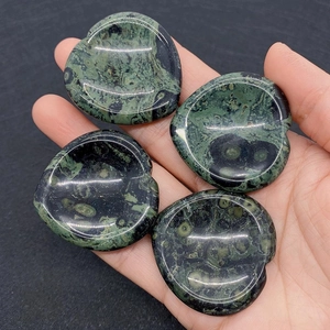 Polished Kambaba Jasper heart worry stones held in hand for massage and anxiety relief