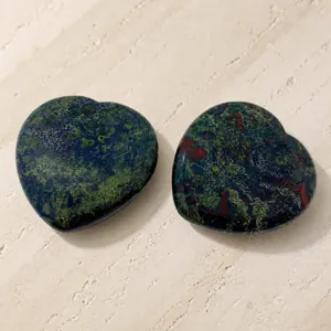 Polished Dragon Blood Jasper heart shaped massage thumb stones on white background