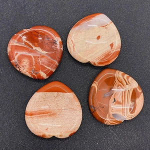 Détail de pierres naturelles polies en forme de cœur avec motifs marbrés rouges et beiges