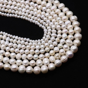 Macro shot of white freshwater pearls with natural texture and glossy finish on black back