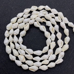 Makro-Detail von natürlichen elfenbeinweißen Spindelschalen-Perlen für DIY-Schmuck