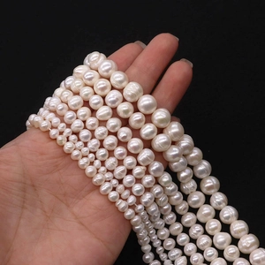 Macro detail of various sizes of white natural freshwater pearls with lustrous surface texture