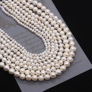 Macro shot of white freshwater pearl strands with natural luster and texture in various sizes