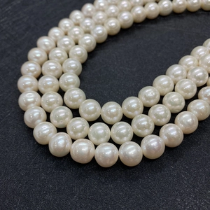 Detailed macro view of 8-12mm white freshwater pearls with natural luster and round shape
