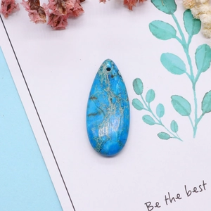 Vue détaillée d'un pendentif goutte en pierre turquoise bleue avec textures marbrées