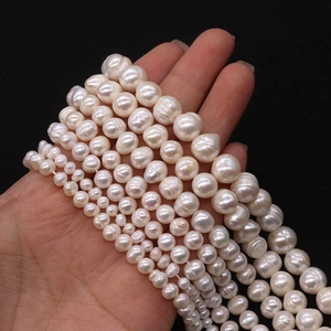 Natural white freshwater pearl strands in various sizes from 2mm to 13mm on black background