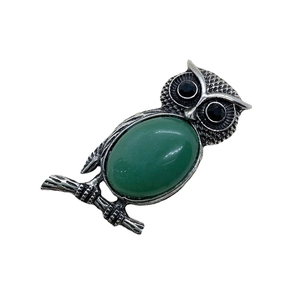 Colgante búho vintage con gema verde y detalles de plumas plateadas sobre fondo blanco