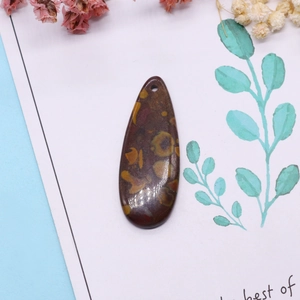 Vue macro d'un pendentif goutte en pierre naturelle avec textures de jaspe jaune