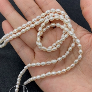Macro shot of 4-5mm rice-shaped natural freshwater pearls showing high luster on silk string