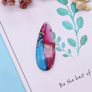 Macro detail of teardrop synthetic turquoise pendant with blue and magenta veined texture
