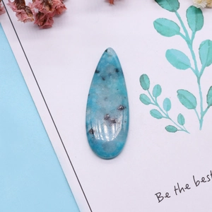 Sky blue drop shaped stone pendant with natural spots on decorative background