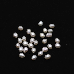 Macro shot of loose rice-shaped white freshwater pearls with pre-drilled holes for DIY jewelry