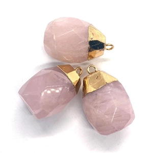 Detailed macro view of three faceted pink quartz pendants with gold plated bail connectors