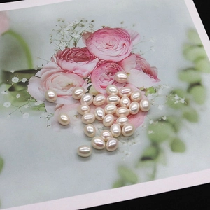 Close-up of pinkish-white rice-shaped freshwater pearls with lustrous iridescent finish