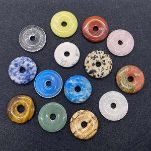 Flat lay of diverse 25mm gemstone ring pendants in natural tiger eye and rose quartz