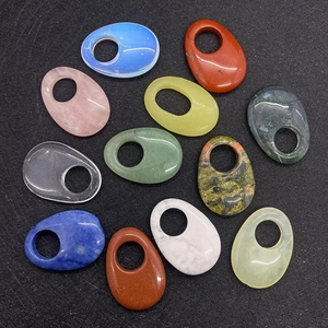 Dettaglio macro di 12 pietre naturali ovali levigate con foro centrale per gioielli DIY