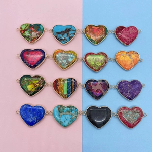 Vue macro de 16 pendentifs coeur en pierre impériale avec bordure dorée et double anneau