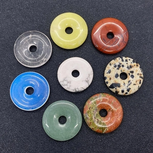 Flat lay of eight colorful 25mm natural stone donut pendants for DIY jewelry making