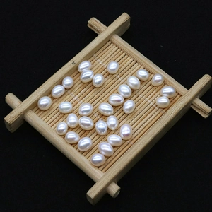 Natural white rice-shaped freshwater pearls on a bamboo tray for DIY jewelry making