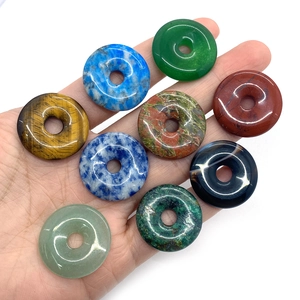 Handheld assorted natural stone donut pendants including tiger eye and lapis lazuli beads