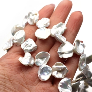 Irregular petal-shaped natural freshwater baroque pearls held in hand for DIY jewelry