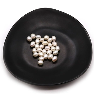 Rice-shaped natural freshwater pearls in black ceramic dish for DIY jewelry making