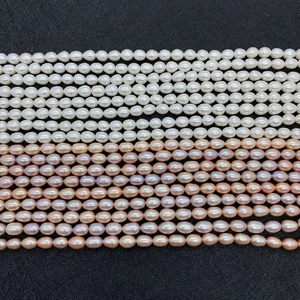 Macro shot of natural freshwater rice pearls in white, pink and purple on black background