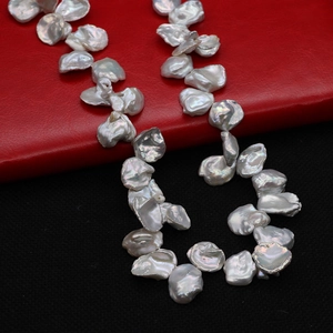 Irregular petal-shaped freshwater baroque pearls with silver-white luster on red base
