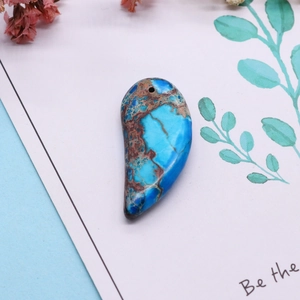 Détail d'un pendentif en turquoise en forme de goutte avec veines naturelles et trou pré-percé
