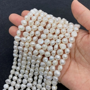 Close-up of natural baroque freshwater pearls with white iridescent luster on black background
