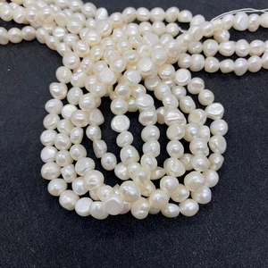 Natural freshwater pearl beads in various shapes on black background for DIY jewelry making