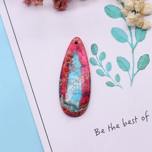 Macro view of teardrop natural stone pendant with colorful marble textures and pre-drilled hole