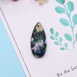 Macro detail of teardrop natural emperor stone pendant with unique colorful textures