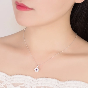 Silver flower pendant necklace with purple gemstone worn by model for elegant daily look
