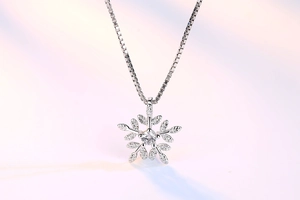 Detailed close-up of a silver snowflake pendant necklace with cubic zirconia and box chain