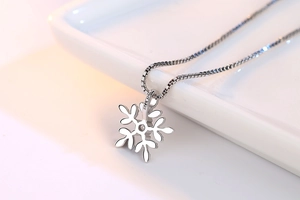 Macro shot of S925 sterling silver snowflake pendant showing the hallmark detail