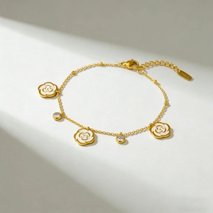 Vintage 18K gold chain bracelet featuring white enamel camellia flowers and clear crystals