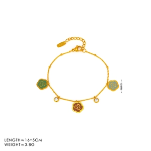 Macro shot of gold bracelet featuring colorful enamel camellia charms and crystals