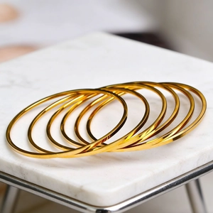 Set di 7 bracciali rigidi in acciaio inossidabile dorato da 2mm su marmo