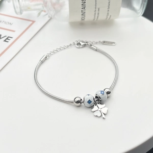 Detaillierte Makroansicht vom silbernen Schlangenarmband mit Kleeblatt und Emailleperlen