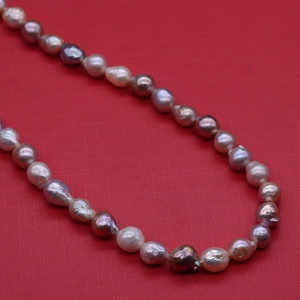Detailed macro shot of irregular 10-11mm Edison pearls necklace in multi-color purple tones