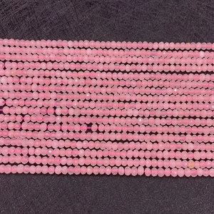 Macro de perles en quartz rose facetté disposées en rangées pour la création de bijoux