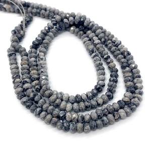 Dettaglio di perle sfaccettate in pietra naturale di pino africano con motivi grigi e neri