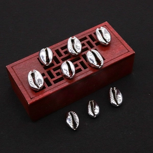 Detailed view of silver electroplated natural cowrie shells on a vintage wooden box