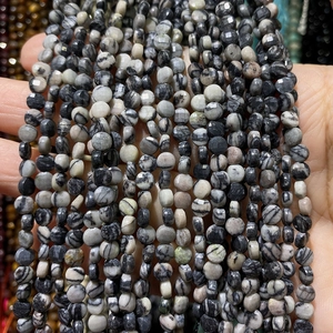 Makroaufnahme von facettierten 4mm Zebrastein-Perlen mit natürlichem Schwarz-Grau-Muster