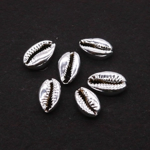 Detailed macro view of six silver-plated metallic conch shell beads for jewelry making