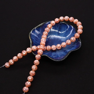 Gros plan de perles de nacre rose facettées présentées sur un plat bleu en pétales