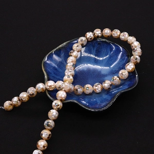 Gros plan de perles mosaïques en nacre d'ormeau 8-20mm avec fini damier aux reflets nacrés