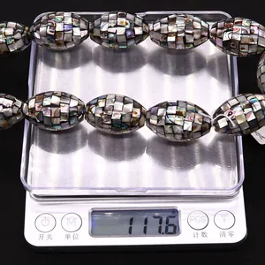 Ovale Mosaik-Muschelperlen wiegen 117,6g auf einer Waage für Schmuckzubehör